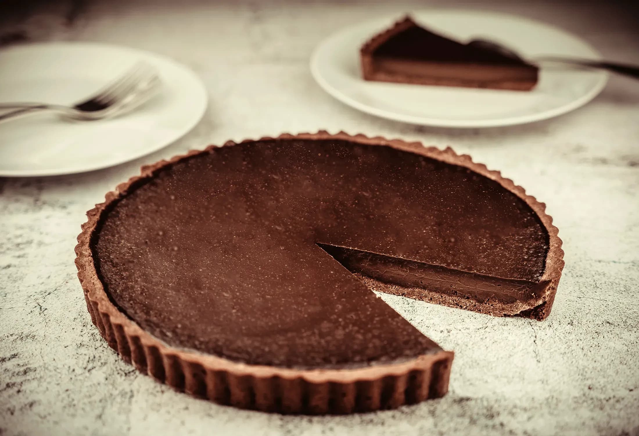 La crostata al cioccolato fondente con la fetta tagliata