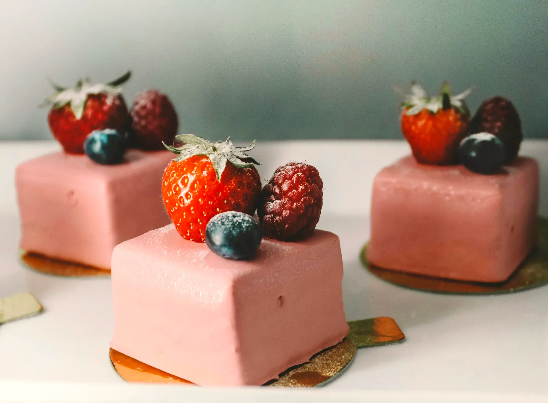 I cubi rosa di mousse alla fragola con i frutti di bosco