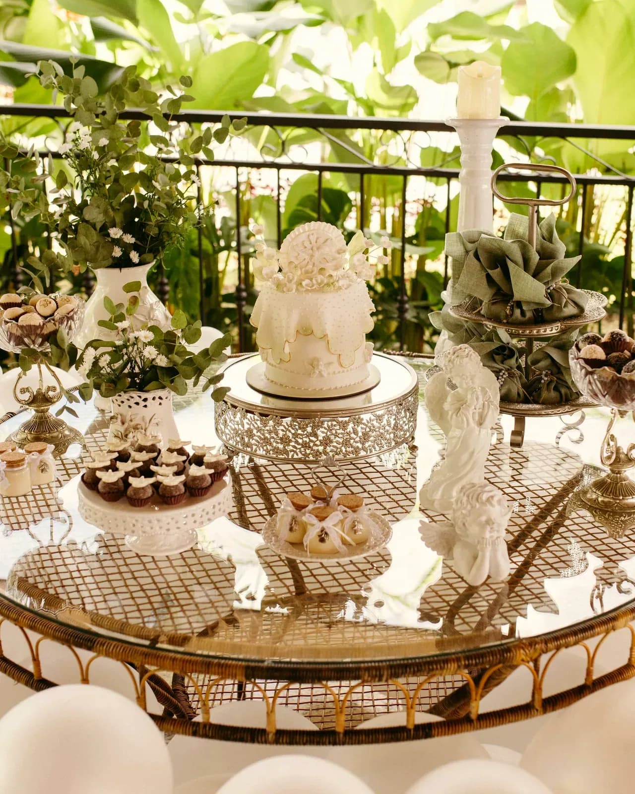 Il tavolo della festa con la torta bianca e i dolcetti, nell'oro