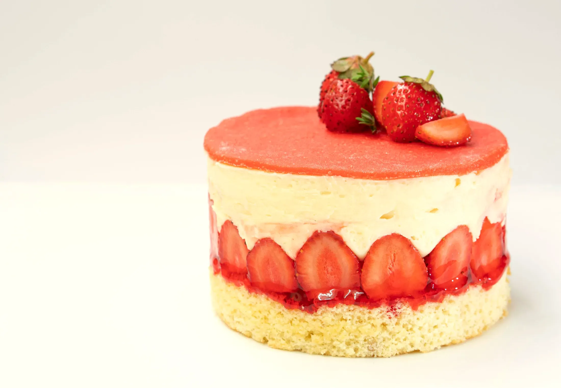 Il fraisier: le fragole intere lungo il bordo, la crema alla vaniglia, la glassa rosa