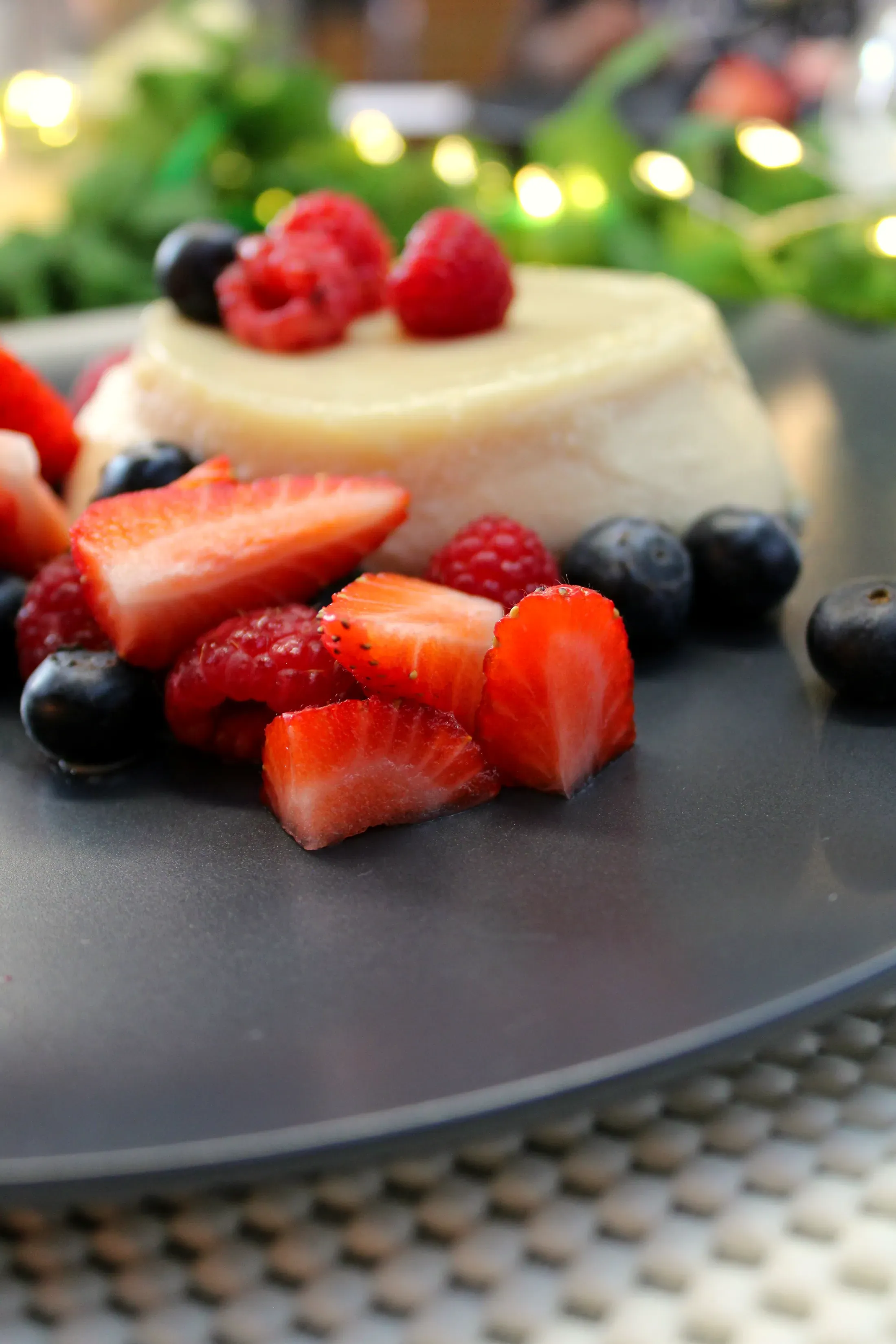 La panna cotta con le fragole e i mirtilli, su fondo scuro
