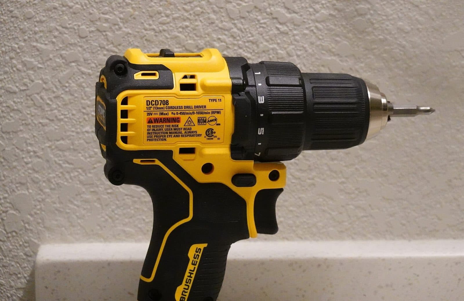 Un trapano avvitatore a batteria giallo e nero, sul banco