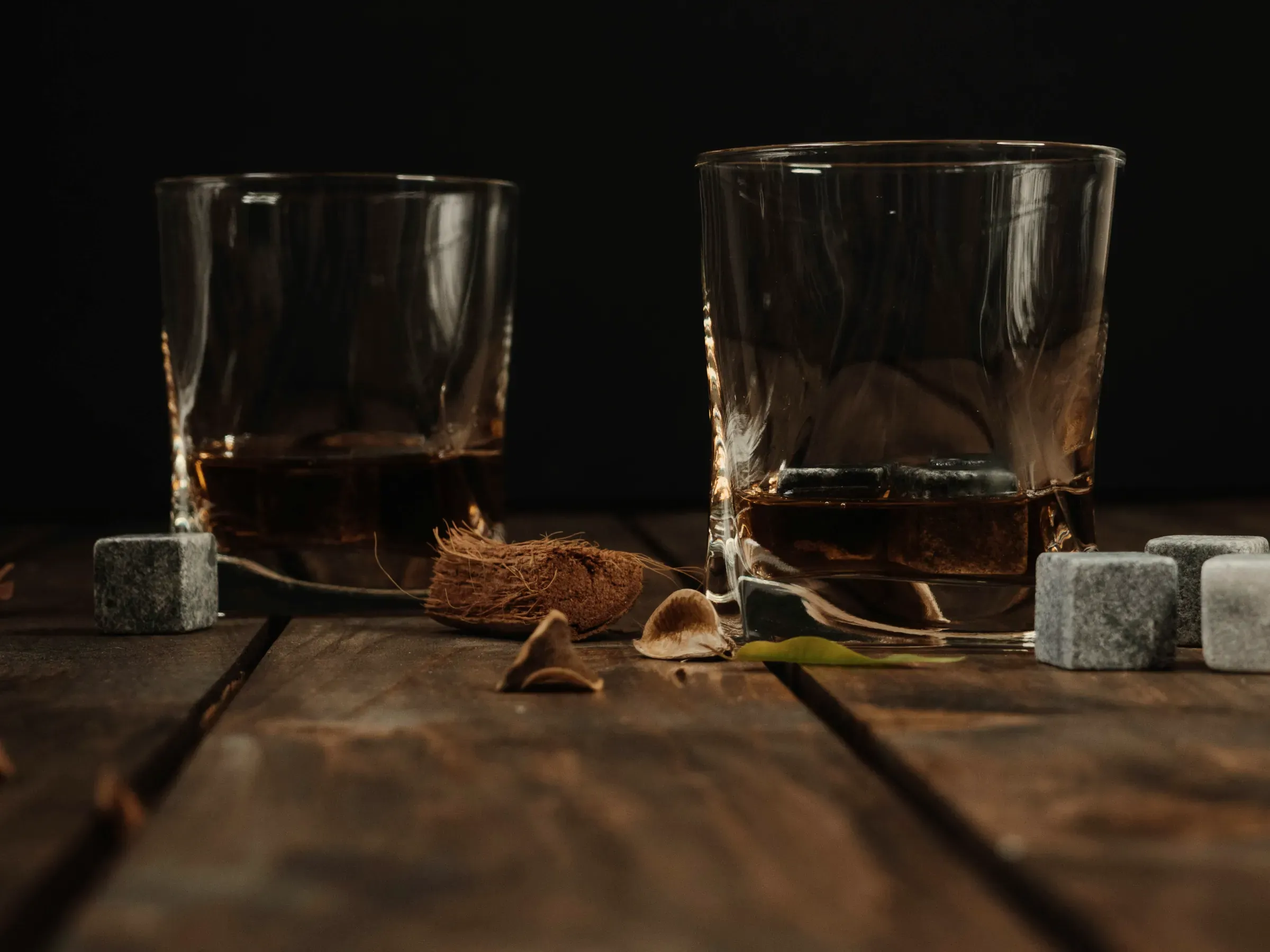Due bicchieri di whisky sul legno, nella penombra