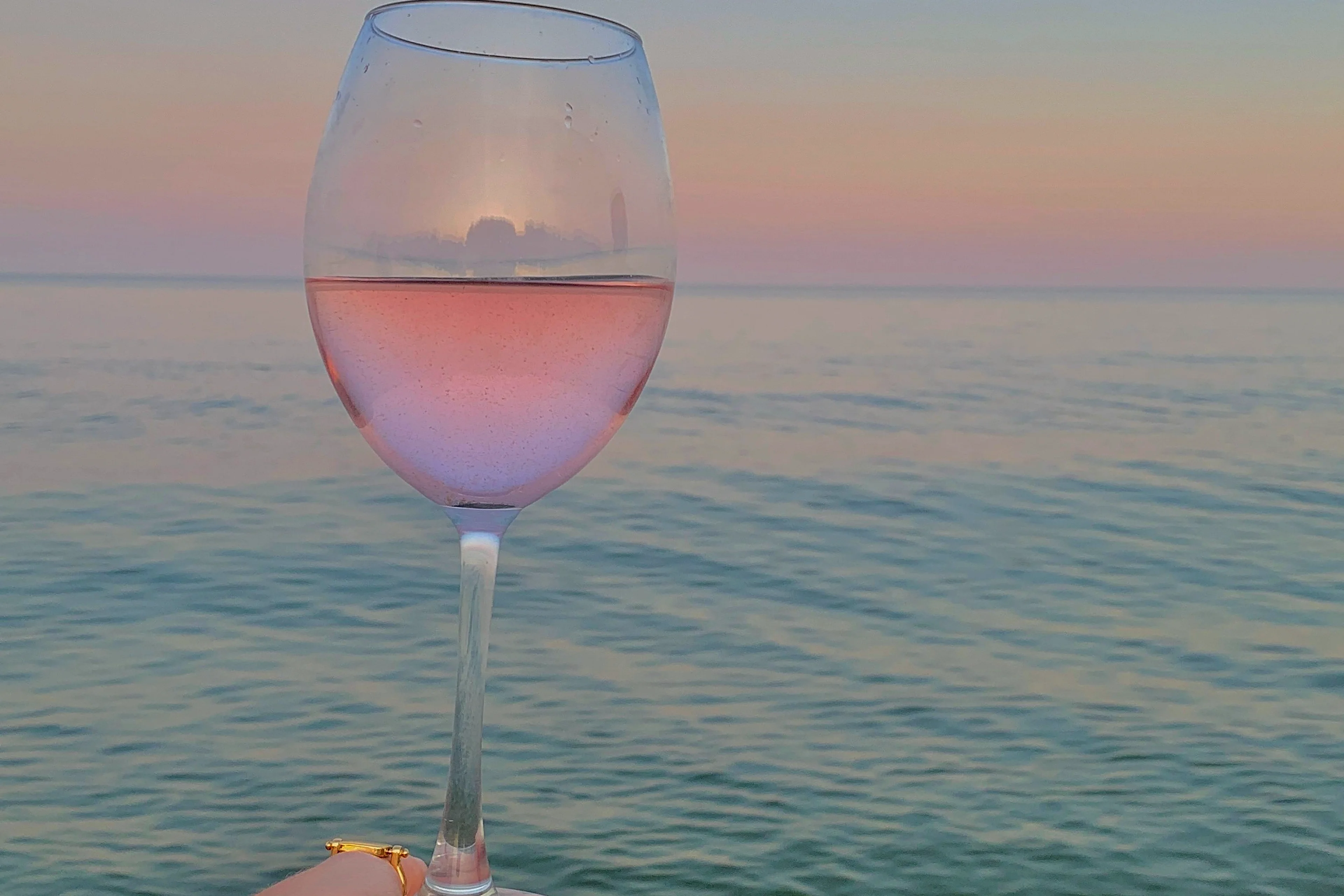 Un calice di rosato davanti al mare, al tramonto