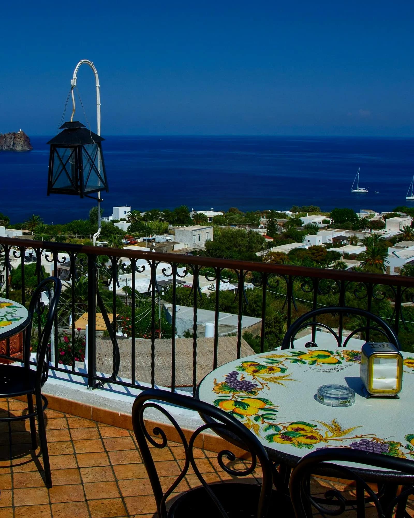 La terrazza con le lanterne e i tavoli, il mare sotto