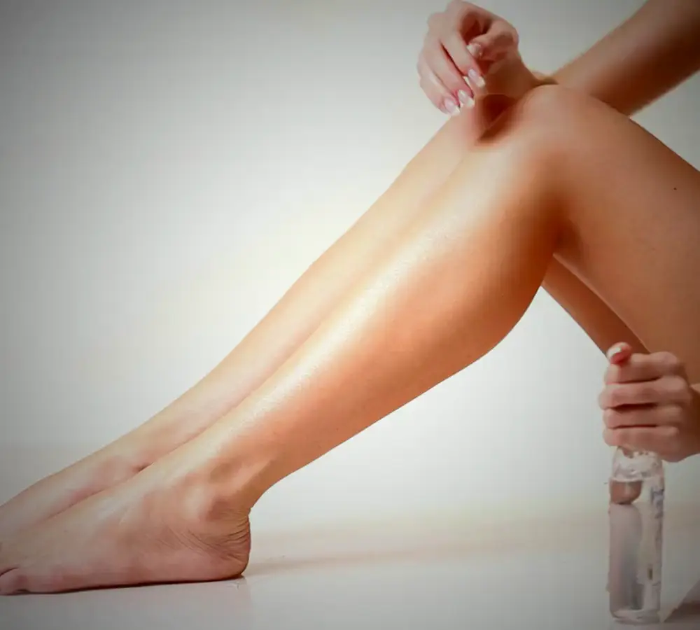 Gambe lisce, una mano che passa la crema